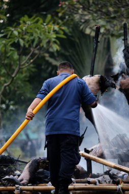 Jakarta, Endonezya. 21 Nisan 2024. İtfaiyeciler, TMII turistik merkezinde Ogoh-ogoh 'u yakan yangını söndürmek için yüksek basınçlı su püskürtüyorlar, Jakarta..