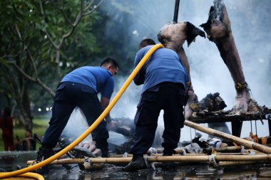 Jakarta, Endonezya. 21 Nisan 2024. İtfaiyeciler, TMII turistik merkezinde Ogoh-ogoh 'u yakan yangını söndürmek için yüksek basınçlı su püskürtüyorlar, Jakarta..