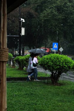 Jakarta, Endonezya. 27 Haziran 2024. Fotoğraf, TMII turist merkezinde şiddetli yağmur yağdığını gösteriyor, Jakarta. Şemsiyeler ve yağmurluklar giyilir..