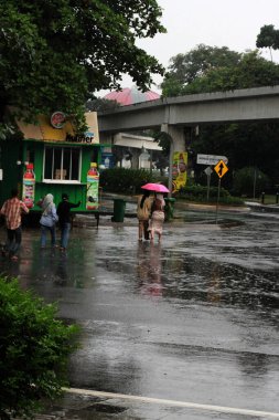 Jakarta, Endonezya. 27 Haziran 2024. Fotoğraf, TMII turist merkezinde şiddetli yağmur yağdığını gösteriyor, Jakarta. Şemsiyeler ve yağmurluklar giyilir..