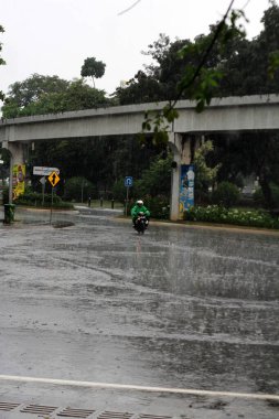 Jakarta, Endonezya. 27 Haziran 2024. Fotoğraf, TMII turist merkezinde şiddetli yağmur yağdığını gösteriyor, Jakarta. Şemsiyeler ve yağmurluklar giyilir..