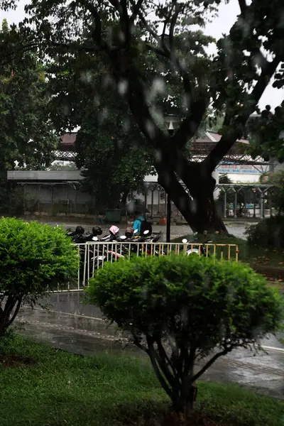 Jakarta, Endonezya. 27 Haziran 2024. Fotoğraf, TMII turist merkezinde şiddetli yağmur yağdığını gösteriyor, Jakarta. Şemsiyeler ve yağmurluklar giyilir..