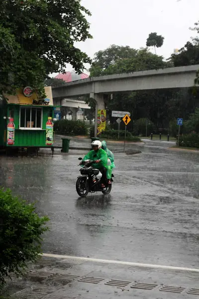 Jakarta, Endonezya. 27 Haziran 2024. Fotoğraf, TMII turist merkezinde şiddetli yağmur yağdığını gösteriyor, Jakarta. Şemsiyeler ve yağmurluklar giyilir..