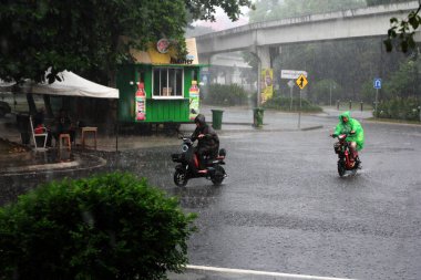 Jakarta, Endonezya. 27 Haziran 2024. Fotoğraf, TMII turist merkezinde şiddetli yağmur yağdığını gösteriyor, Jakarta. Şemsiyeler ve yağmurluklar giyilir..