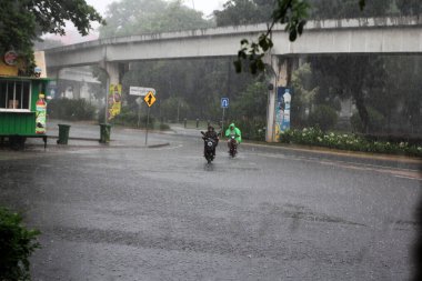 Jakarta, Endonezya. 27 Haziran 2024. Fotoğraf, TMII turist merkezinde şiddetli yağmur yağdığını gösteriyor, Jakarta. Şemsiyeler ve yağmurluklar giyilir..