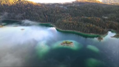 Sonbaharda, Almanya 'da Eibsee Gölü' nün güzel bir insansız hava aracı ile çekilmiş görüntüleri. Turkuaz suyu. Yeşillik ağaçlar. Gün doğumu.