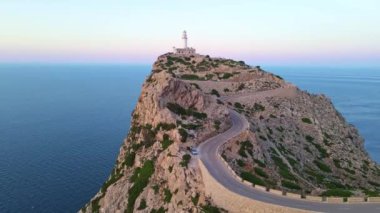 Serra de Tramuntana Mallorca İspanya 'daki Formentor deniz fenerinde kayalık uçurum ve yola yayılan parlak altın ışık. Hiçbir araba geçmiyor..