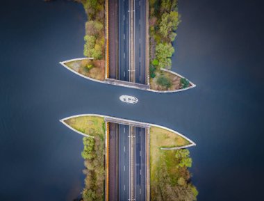 Aquaduct Veluwemeer, Hollanda. İHA 'nın hava görüntüsü. Bir yelkenli, otobanın üstündeki göldeki su kanalından geçiyor. Alışılmadık ulaşım resmi.