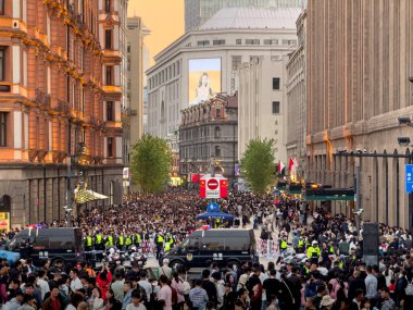 Çevrede polis varlığı ile çevrili bir halk etkinliği için bir araya gelen çeşitli insanlarla dolu canlı ve canlı bir şehir manzarası.