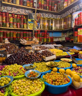 Fas pazarında çeşitli kaplarda ve kaselerde zeytin ve hurma sergilenmektedir..