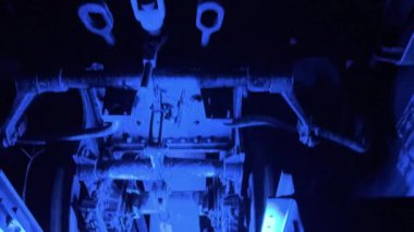 Bu eser, çarpan mavi ışıklarla eşsiz bir şekilde aydınlatılmış bir aracın bagajının sanatsal görünümünü sergiliyor.