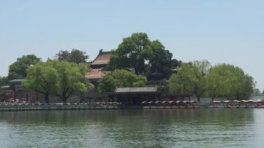 Bereketli yeşillik ve sakin sularla çevrili tarihi binaları gösteren güzel, sakin bir manzara.