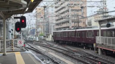 Yoğun ve hareketli bir şehir tren istasyonu sahnesi, kırmızı trafik işaretlerinin yer aldığı yağmurlu havada güzel bir şekilde çekildi.