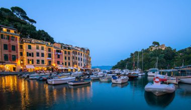 Portofino limanı alacakaranlıkta aydınlanıyor ve rengarenk liman binaları ve sakin sularda yüzen sayısız tekne sergileniyor. Huzurlu sahne, bu sahil kasabasının cazibesini yakalıyor..