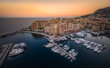 Güneş batarken yatlar sakin bir marinada dizilir ve su ve binaların üzerine sıcak renkler dökülür. Huzurlu sahil kenti deniz kenarında lüks bir yaşam sunuyor..