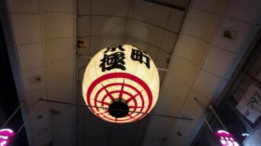 Çok güzel hazırlanmış bir Japon feneri canlı ve hareketli bir caddenin canlı atmosferini aydınlatıyor.