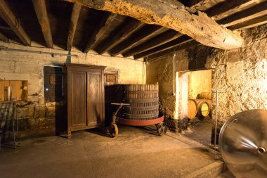 Saint Emilion 'da geleneksel bir mahzende şarap yapma ekipmanı ve tahta fıçılar düzenlenir. Loş ışıklandırma, taş duvarları ve kırsal atmosferi ön plana çıkarıyor ve klasik bir atmosfer yaratıyor..