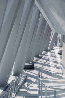 Keskin açılı, kendine özgü gölgeler oluşturan iç mekan mimari tasarımı. Yapı beton ve cam kullanıyor, davetkar bir atmosfer yaratıyor..