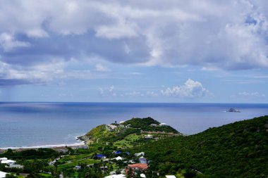 St. Maarten 'in doğu yakasındaki Guana Körfezi bu bulutlu günde sakin ve Pelikan Anahtarı sağda görünüyor..