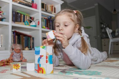 Little cute girl spending time in the playroom, soft focus background