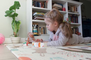 Little cute girl spending time in the playroom, soft focus background