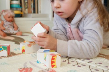 Little cute girl spending time in the playroom, soft focus background