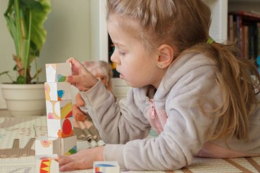 Little cute girl spending time in the playroom, soft focus background