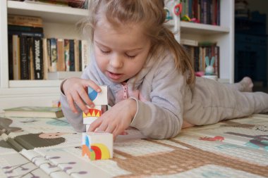 Little cute girl spending time in the playroom, soft focus background