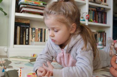 Little cute girl spending time in the playroom, soft focus background
