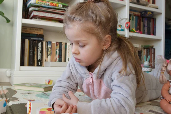 Little cute girl spending time in the playroom, soft focus background