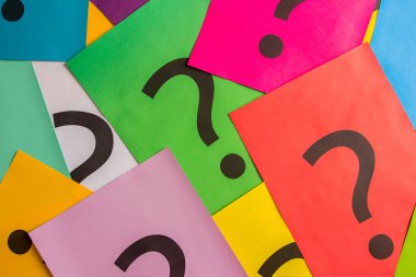 Black question marks on the colored papers, top view