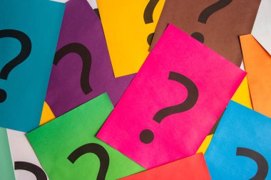 Black question marks on the colored papers, top view