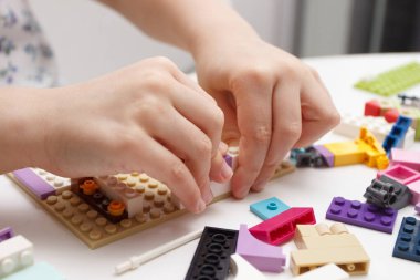 Çocuk inşaatçı tuğlalarıyla, oyuncaklarla oynar, yumuşak odaklı arka planla çalışır