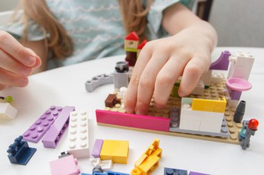 Çocuk inşaatçı tuğlalarıyla, oyuncaklarla oynar, yumuşak odaklı arka planla çalışır