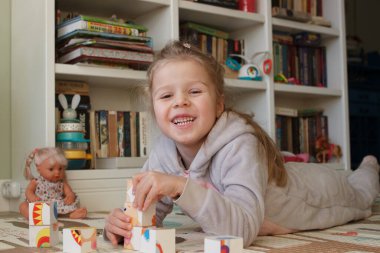 Little cute girl reading a book in the room, soft focus background. Education at home concept.