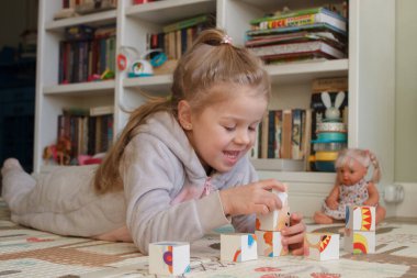 Little cute girl reading a book in the room, soft focus background. Education at home concept.