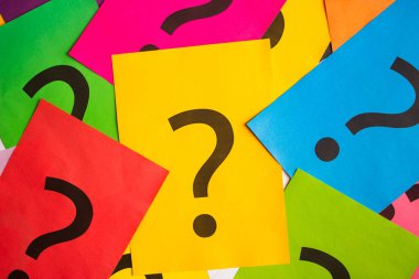 Black question marks on the colored papers, top view