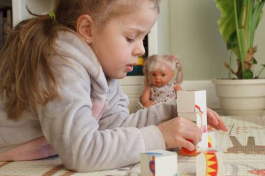Little cute girl reading a book in the room, soft focus background. Education at home concept.