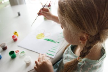 Little child draws with watercolor, concept of education in the kindergarten, soft focus background
