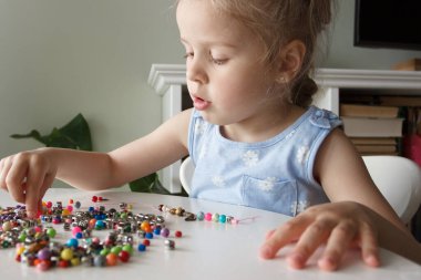 İplik ve renkli boncuklardan bilezik yapma süreci, hobi ya da eğlence kavramı