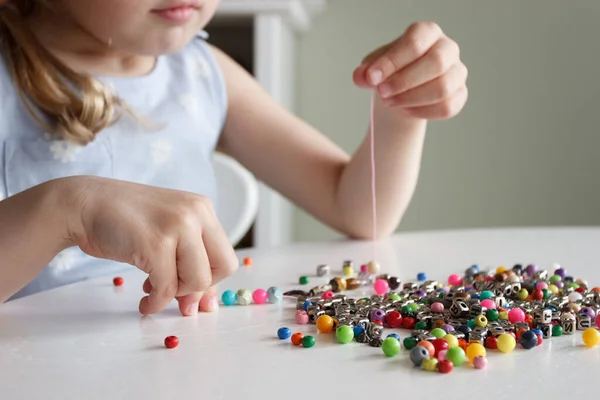 Stock image Process of making a bracelet from a thread and colored beads, concept of hobby or leisure