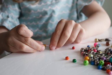 İplik ve renkli boncuklardan bilezik yapma süreci, hobi ya da eğlence kavramı