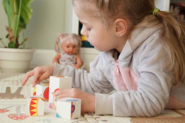 Little cute girl spending time in the playroom, soft focus background