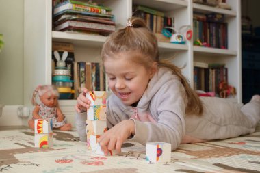Little cute girl spending time in the playroom, soft focus background