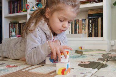 Little cute girl spending time in the playroom, soft focus background