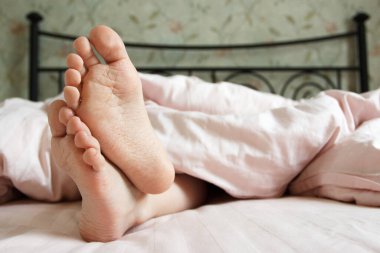 Ayaklarını yatağın üzerinde hafif bir battaniyenin altına koy. Uyumak mı yoksa sabah uyanmak mı?