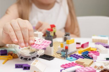 Çocuk inşaatçı tuğlalarıyla, oyuncaklarla oynar, yumuşak odaklı arka planla çalışır