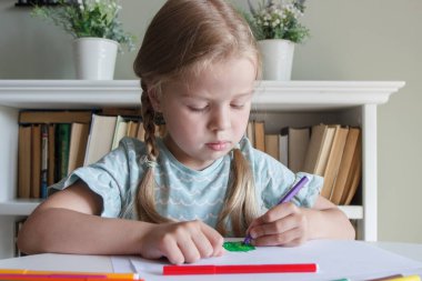 Renkli keçeli kalemlerle resim çizen sevimli bir çocuk. Hobi ve eğitim kavramı