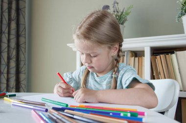 Renkli keçeli kalemlerle resim çizen sevimli bir çocuk. Hobi ve eğitim kavramı