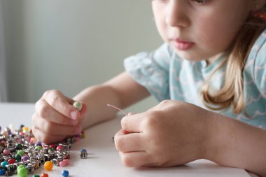 İplik ve renkli boncuklardan bilezik yapma süreci, hobi ya da eğlence kavramı